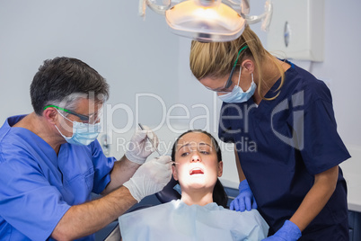 Dentist and nurse examining a scared patient