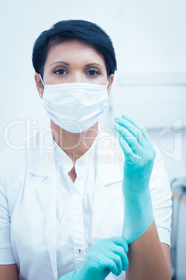 Female dentist wearing surgical mask and gloves