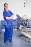 Cheerful dentist standing with arms crossed