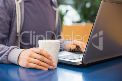 Young student using his laptop in cafe