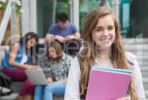 Pretty student smiling at camera outside