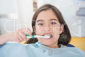 Young patient brushing her teeth