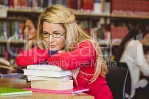 Thoughtful mature student leaning on a stack of books