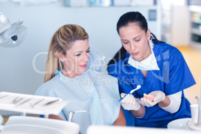 Dentist showing patient model of teeth