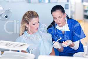 Dentist showing patient model of teeth