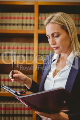 Focused female librarian holding textbook