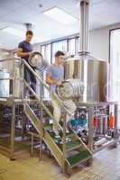 Young men carrying keg smiling at camera