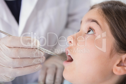 Pediatric dentist examining his nervous young patient