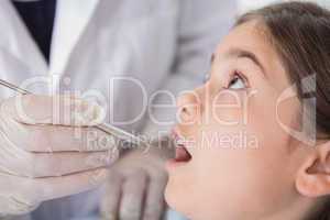 Pediatric dentist examining his nervous young patient