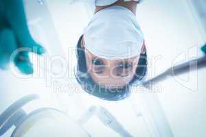 Female dentist in surgical mask holding dental tools