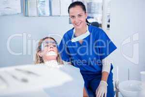 Dentist and her assistant smiling at camera