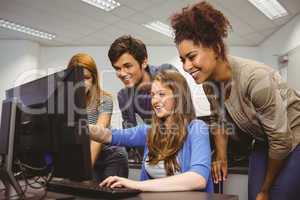 Cheerful student pointing at computer