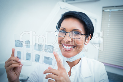 Happy female dentist holding x-ray