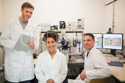 Biochemistry students using large microscope and computer