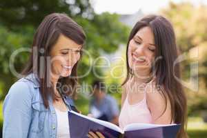 Pretty students reading from notepad