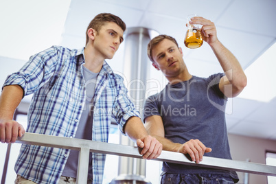 Men holding beaker with beer