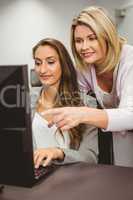 Teacher showing something on screen to student