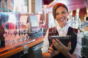 Focused barmaid using touchscreen till