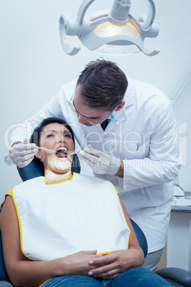 Male dentist examining womans teeth