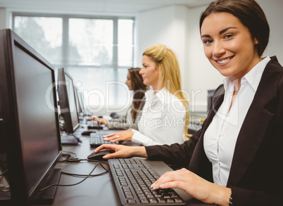 Happy woman in computer room smiling at camera