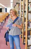 Mature student studying in the library with tablet