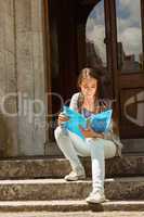 Smiling student sitting and reading book