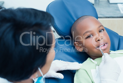 Dentist examining boys teeth in the dentists chair