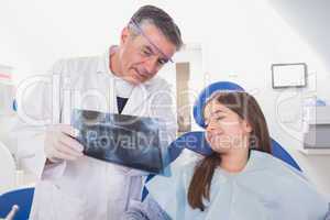 Pediatric dentist explaining to young patient the x-ray