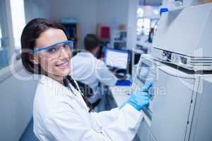 Smiling young chemist using the machine