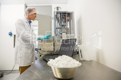 Pharmacist using machinery to make medicine