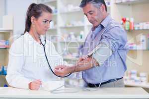 Trainee listening to patients pulse with stethoscope