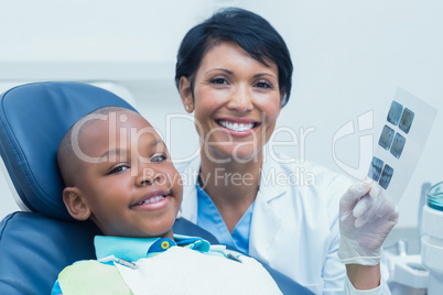 Female dentist showing boy his mouth x-ray