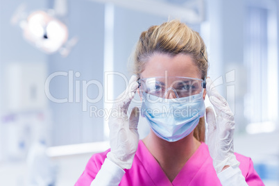 Dentist in surgical mask and protective glasses