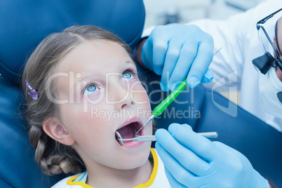 Male dentist examining girls teeth