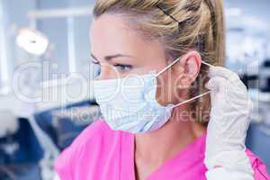 Dentist putting on her surgical mask