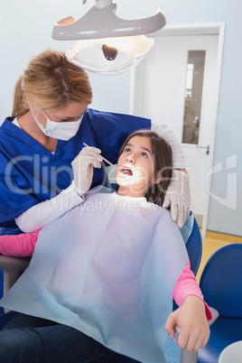 Pediatric dentist examining her young patient