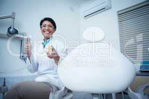 Dentist gesturing thumbs up while holding mouth model