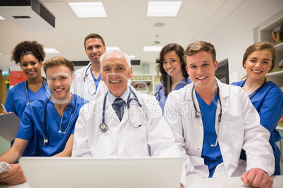 Medical students and professor using laptop