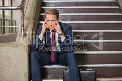 Stressed businessman sitting on steps