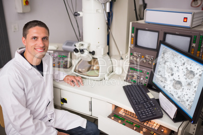 Biochemistry student using large microscope and computer