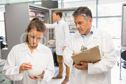 Junior pharmacist mixing a medicine being supervised