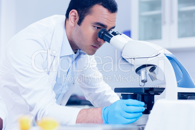 Science student looking through microscope in the lab