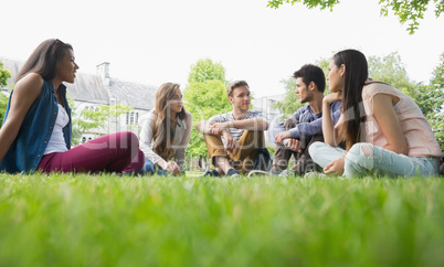 Happy students sitting outside on campus