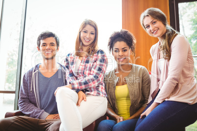 Happy students sitting on couch smiling at camera