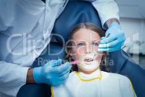 Male dentist examining girls teeth