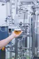 Hand showing a beaker of beer