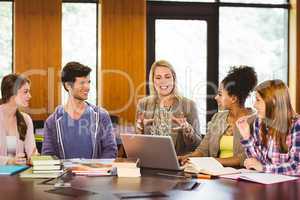 Smiling students and teacher in library