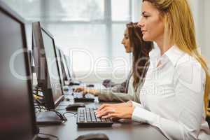 Two focused women working in computer room