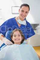 Pediatric dentist putting on her young patient the scrubs