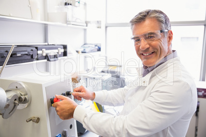 Senior pharmacist using machine to make medicine